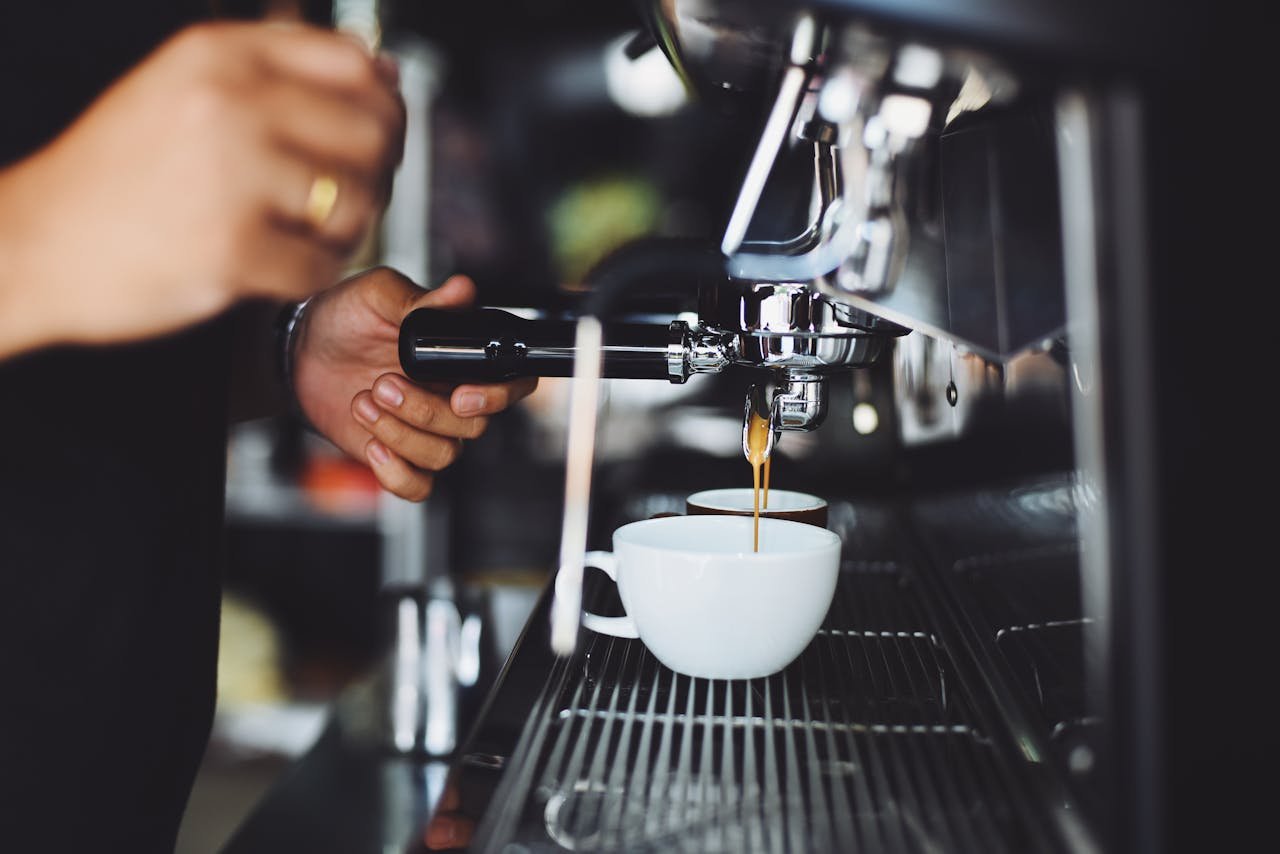 Close-up of a barista making espresso with a coffee machine in a café.